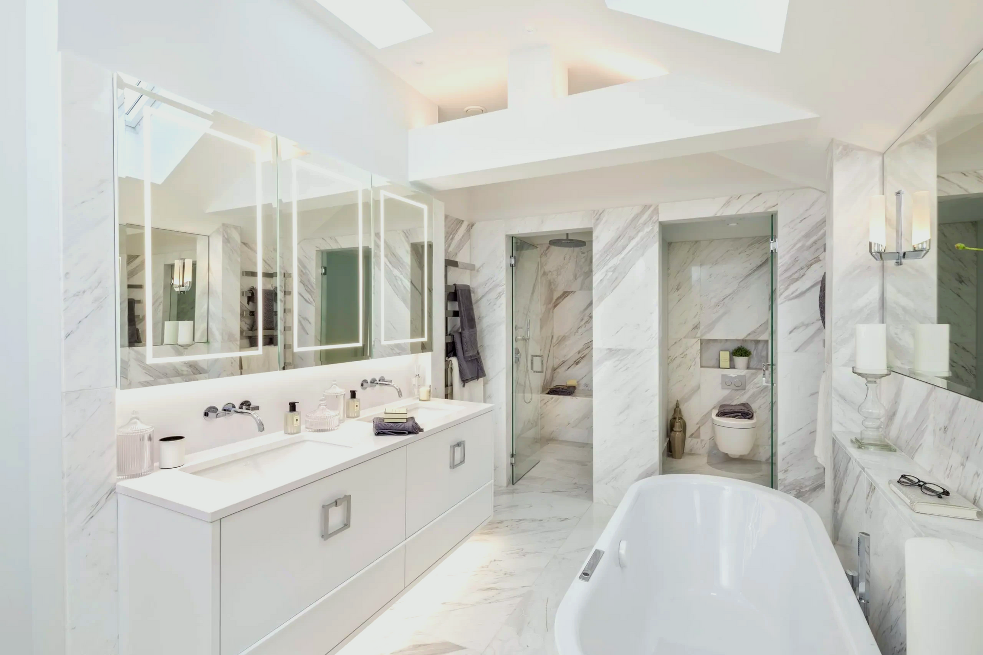 Luxurious bathroom with a white marble wall, a modern tub, and gold fixtures, showcasing premium bathroom tiling.