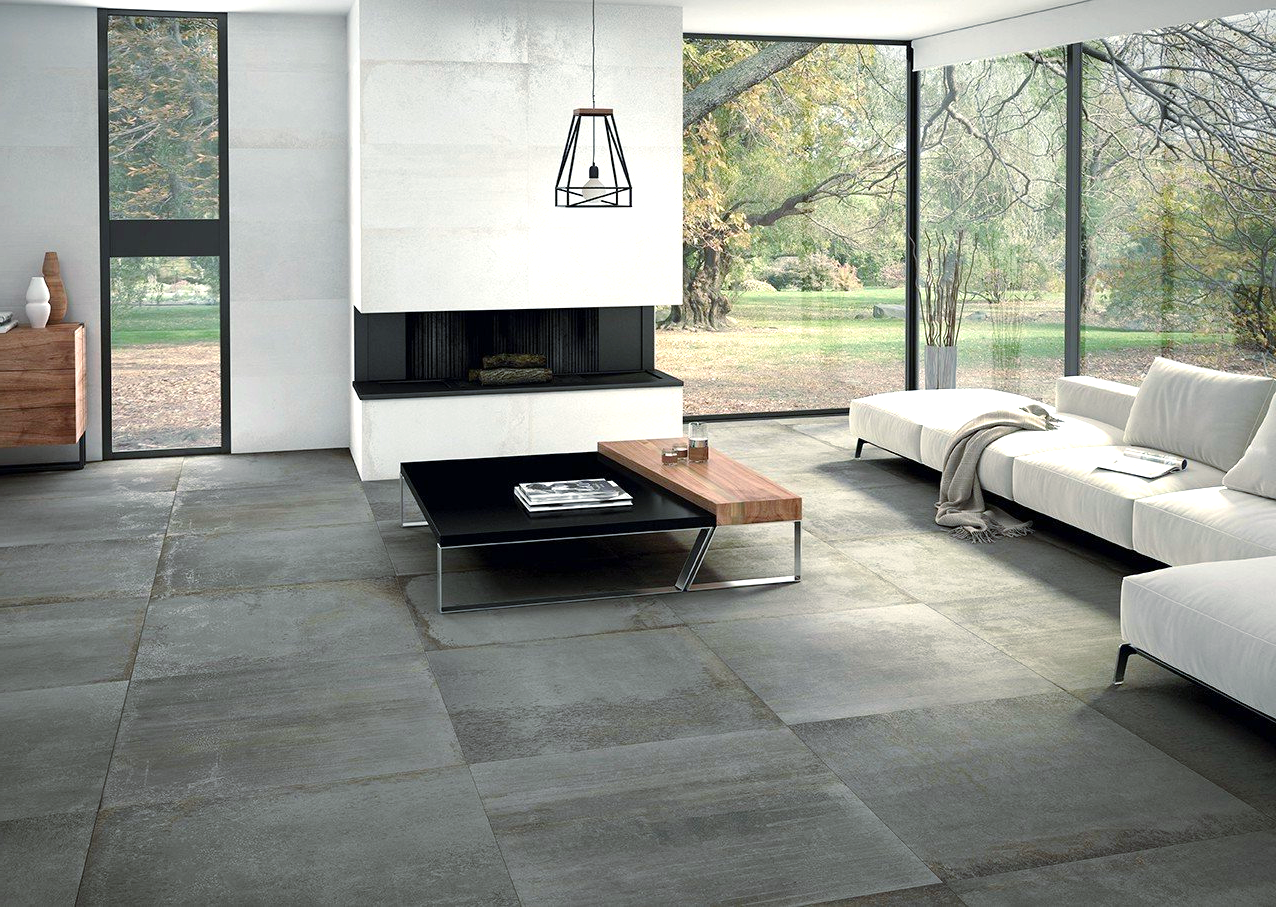 Modern living room with concrete flooring, fireplace, and large windows overlooking a green yard.