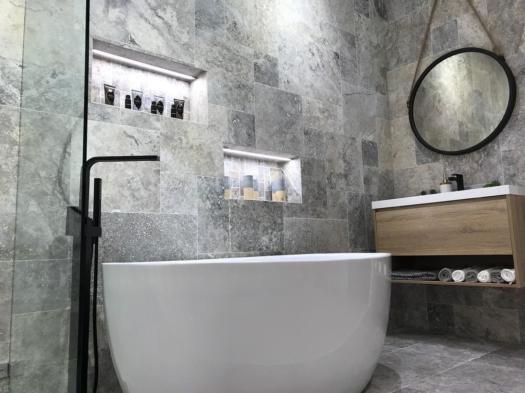 A bathroom with a bathtub, sink, mirror and shower.