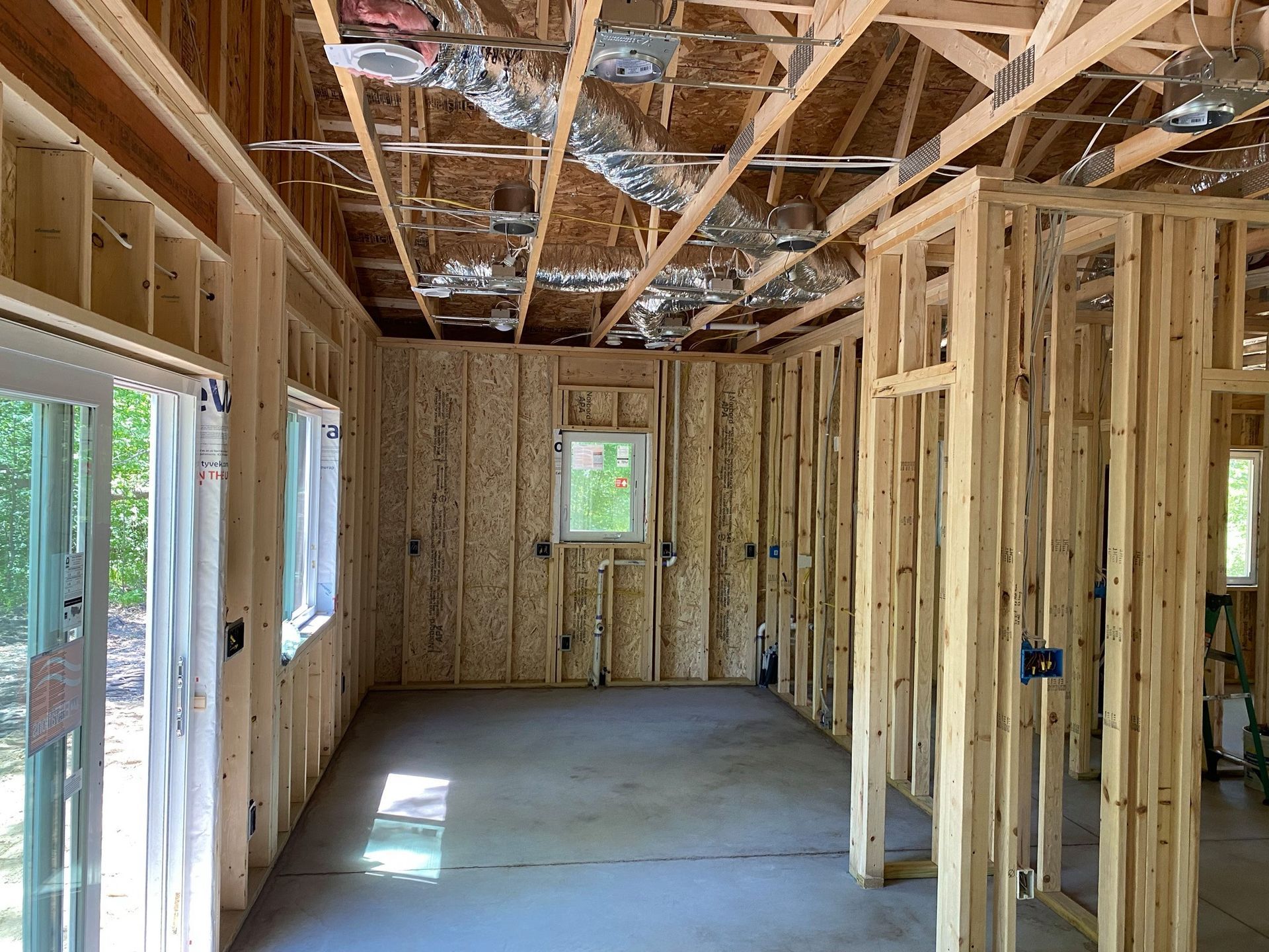 A room in a house that is being built with wooden beams and windows.