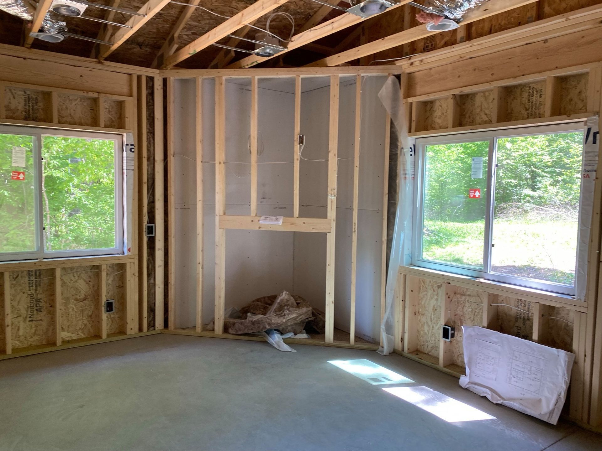 A room in a house under construction with a lot of windows.