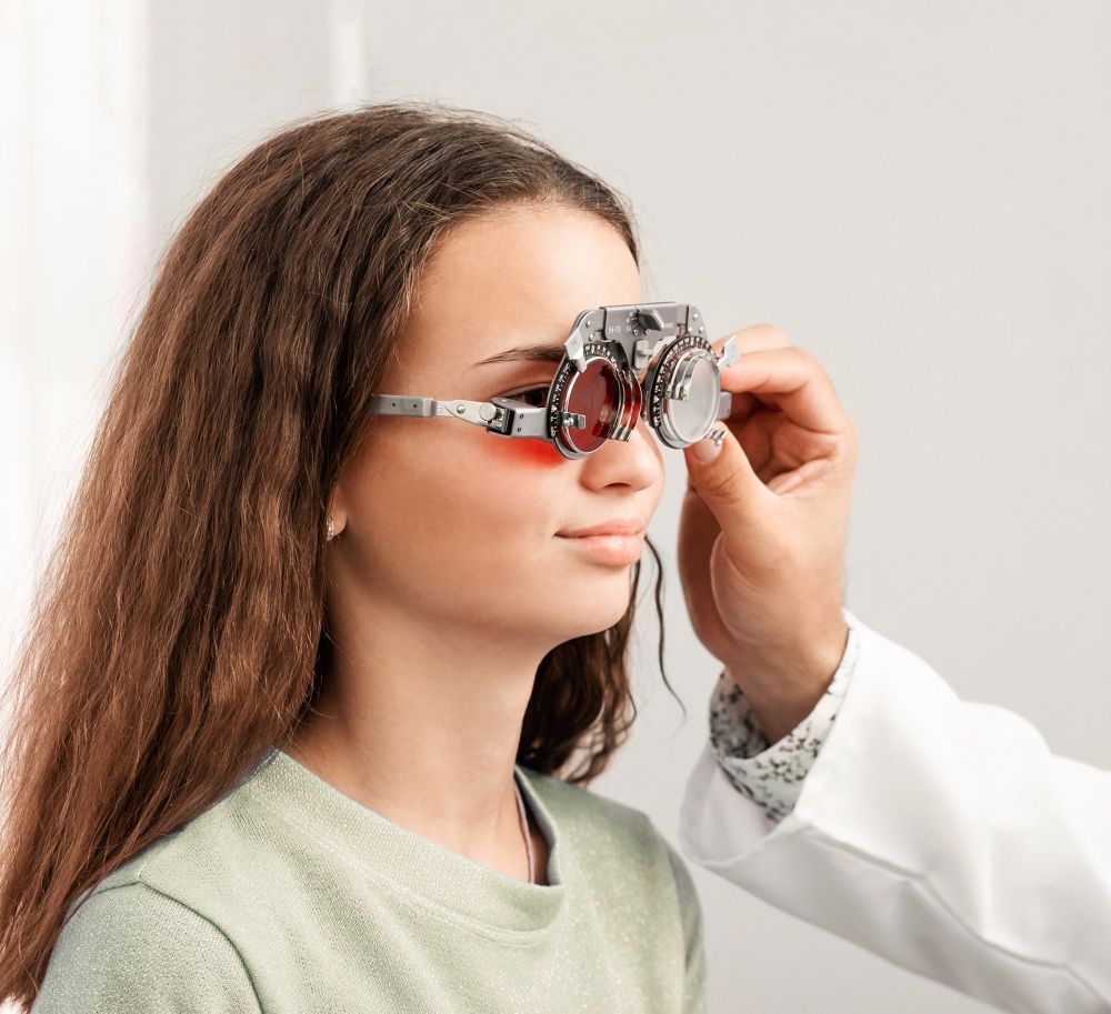 Optometrist adjusting a woman’s eyeglasses during an eye exam