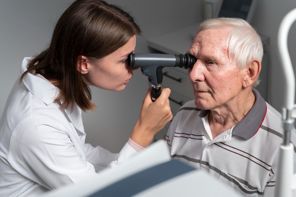 Clinician examines an elderly patient’s eye with an ophthalmoscope in a clinic setting