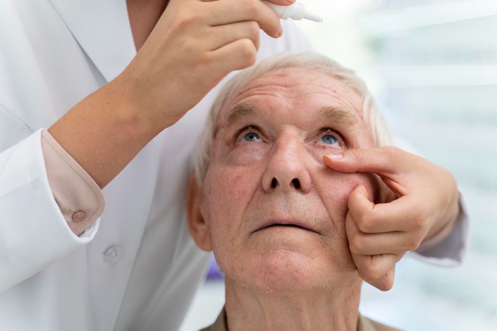 Doctor examining an elderly patient’s eye with a gloved hand