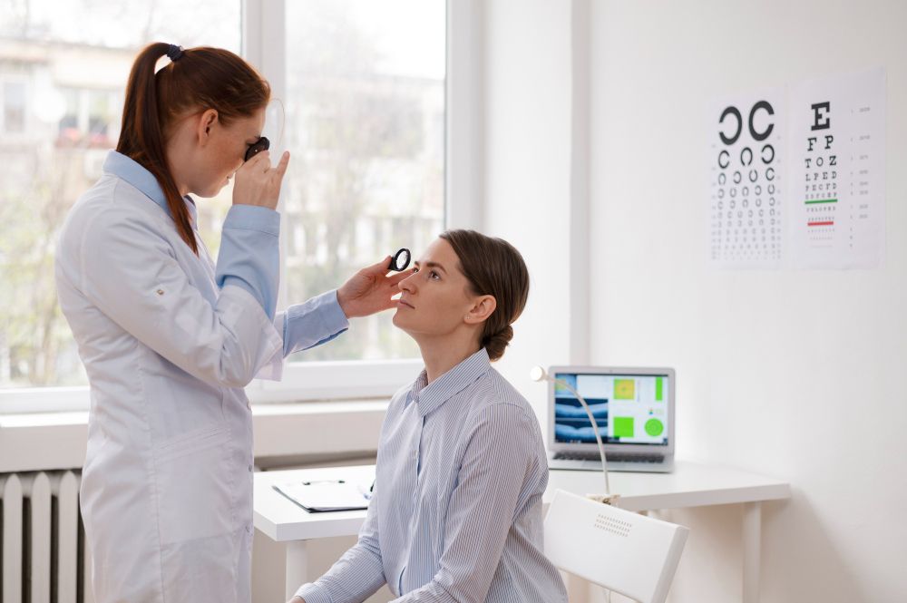 Eye doctor examining a patient in a bright clinic, with an eye chart and computer screen nearby