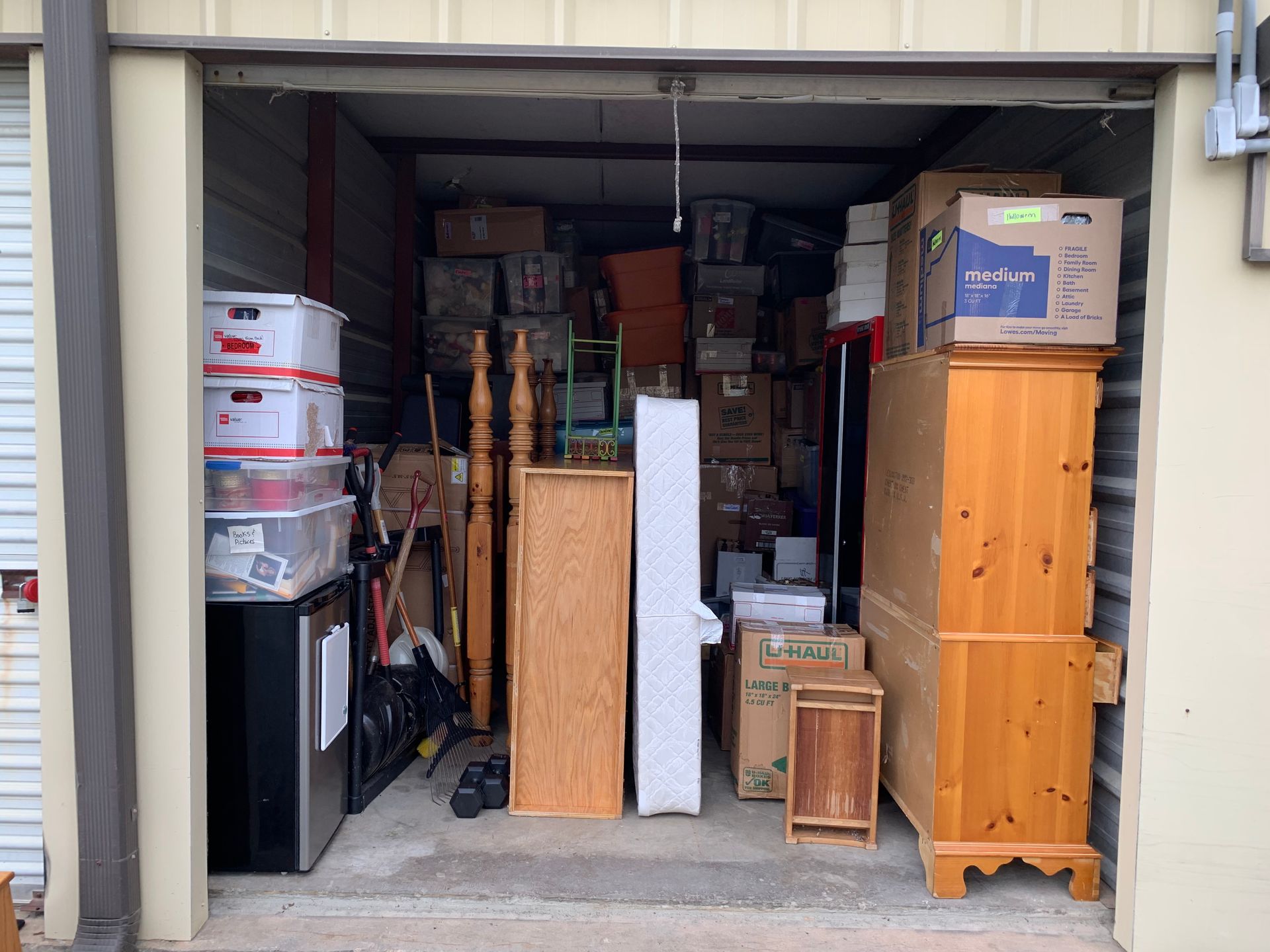 A storage unit filled with lots of furniture and boxes.