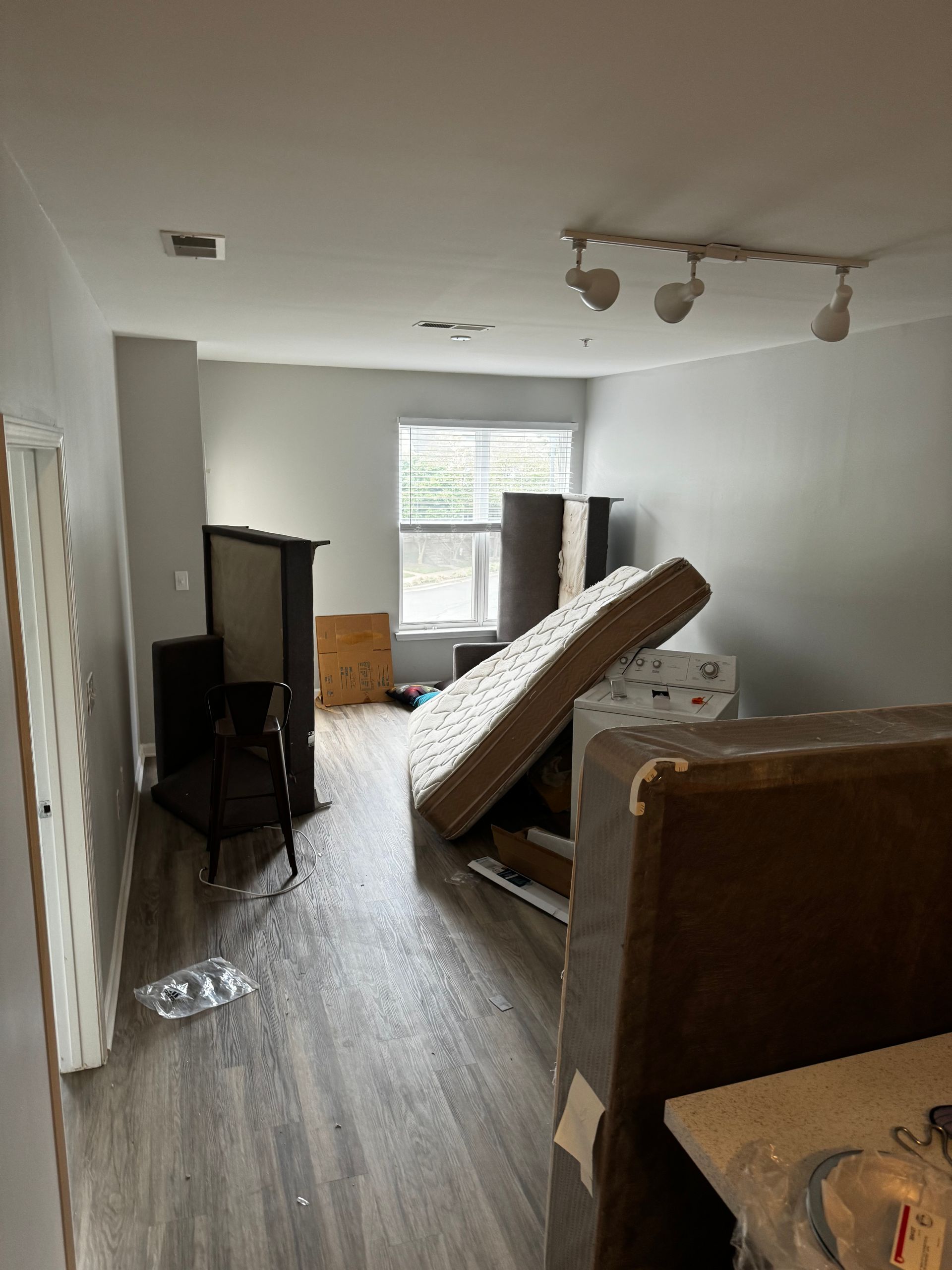 A living room with a mattress on the floor.