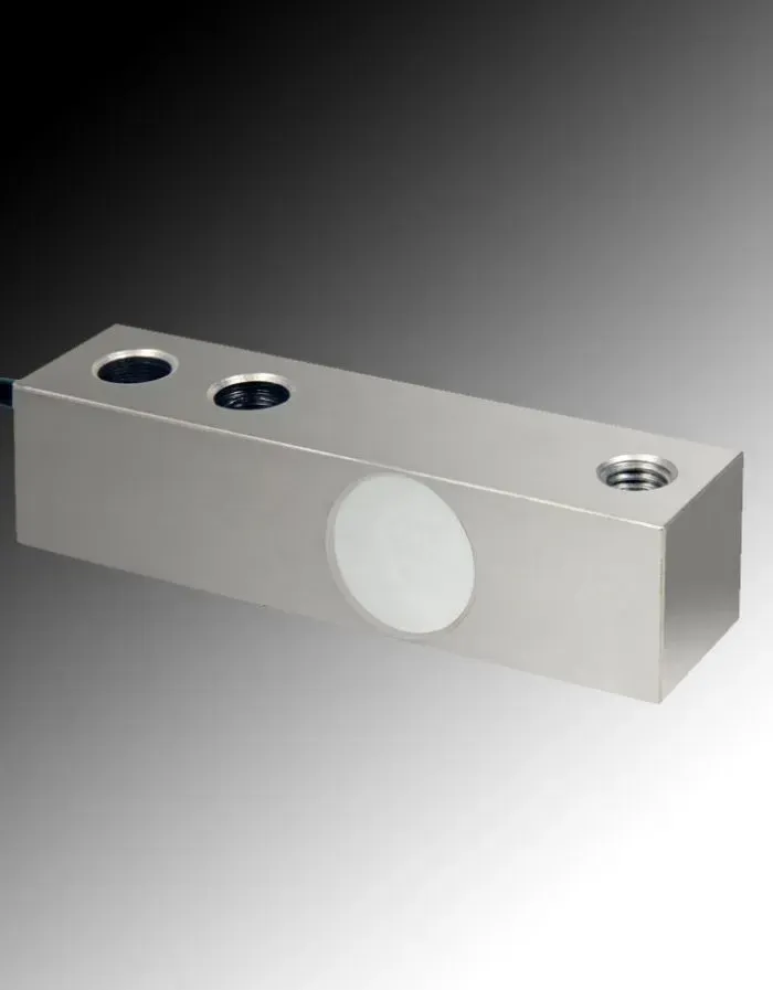 Cella di carico in argento con etichetta circolare e fori per viti.