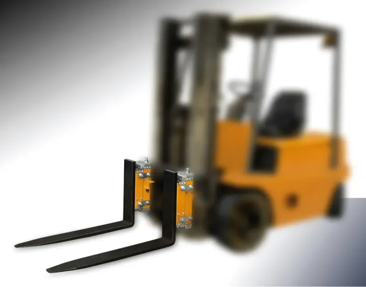 Un carrello elevatore nero inforca davanti a un carrello elevatore giallo.
