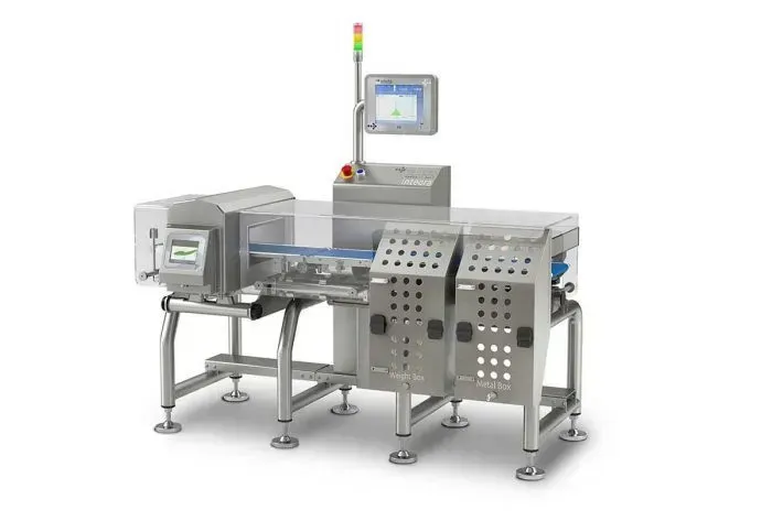 Macchina industriale per la lavorazione degli alimenti con nastro trasportatore, metal detector e pannello di controllo.