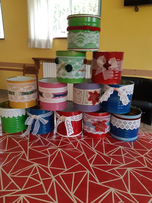 Scatole regalo colorate impilate su un tappeto rosso a fantasia, in una stanza gialla.