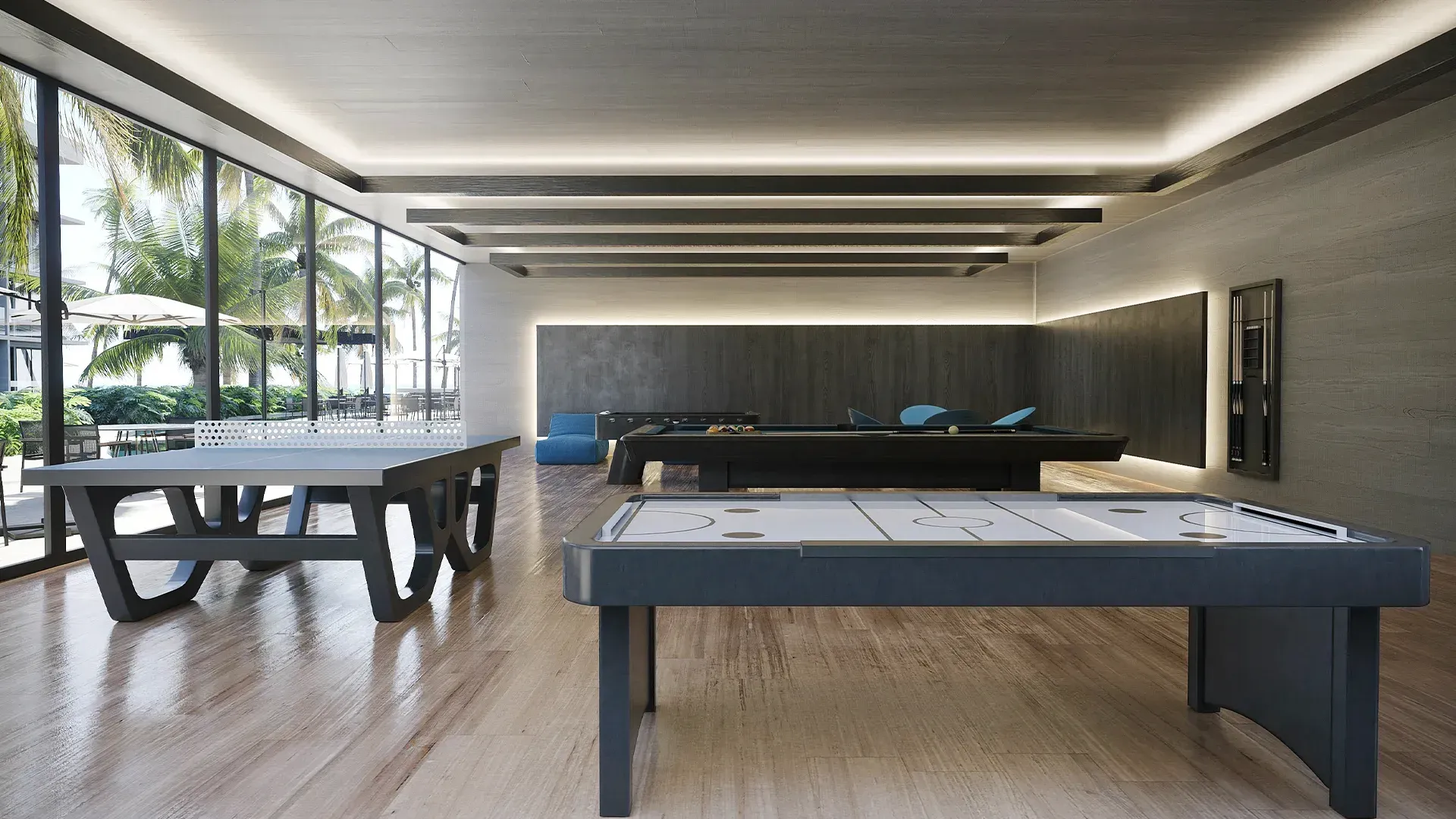Uma grande sala com mesa de sinuca e mesas de pingue-pongue