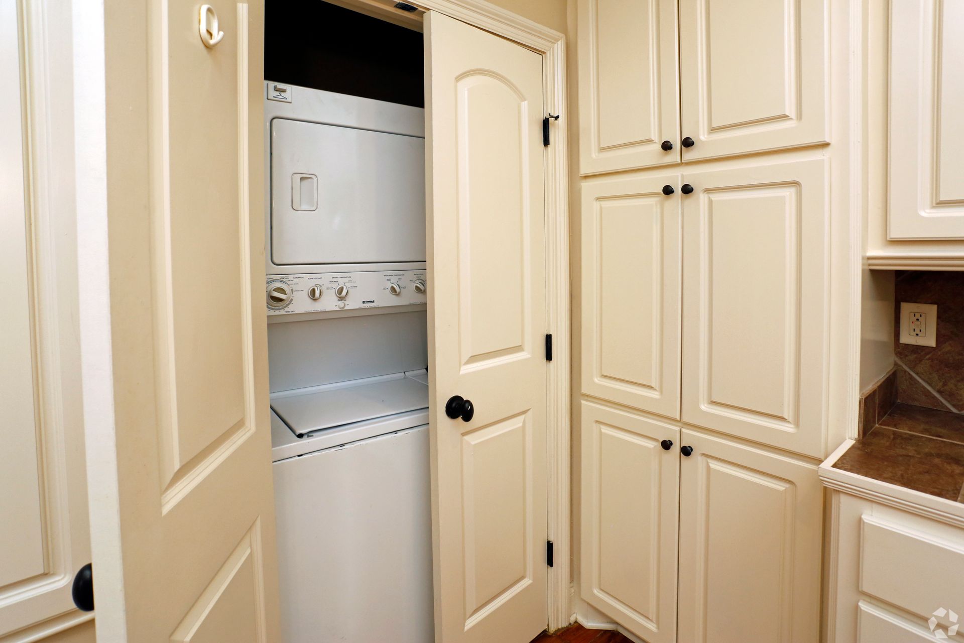 A washer and dryer are stacked on top of each other in a laundry room.