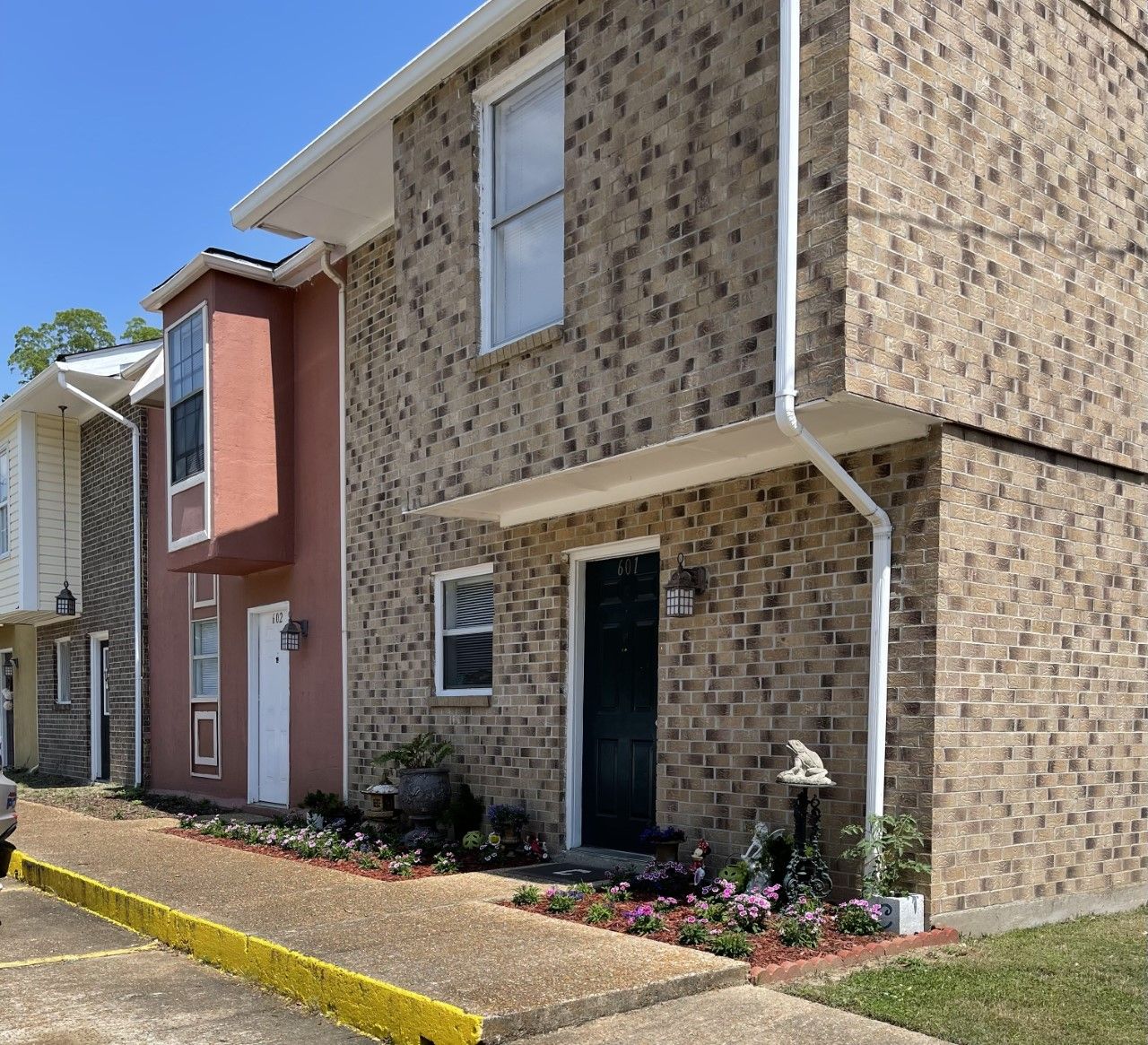 A brick apartment building with a yellow curb in front of it