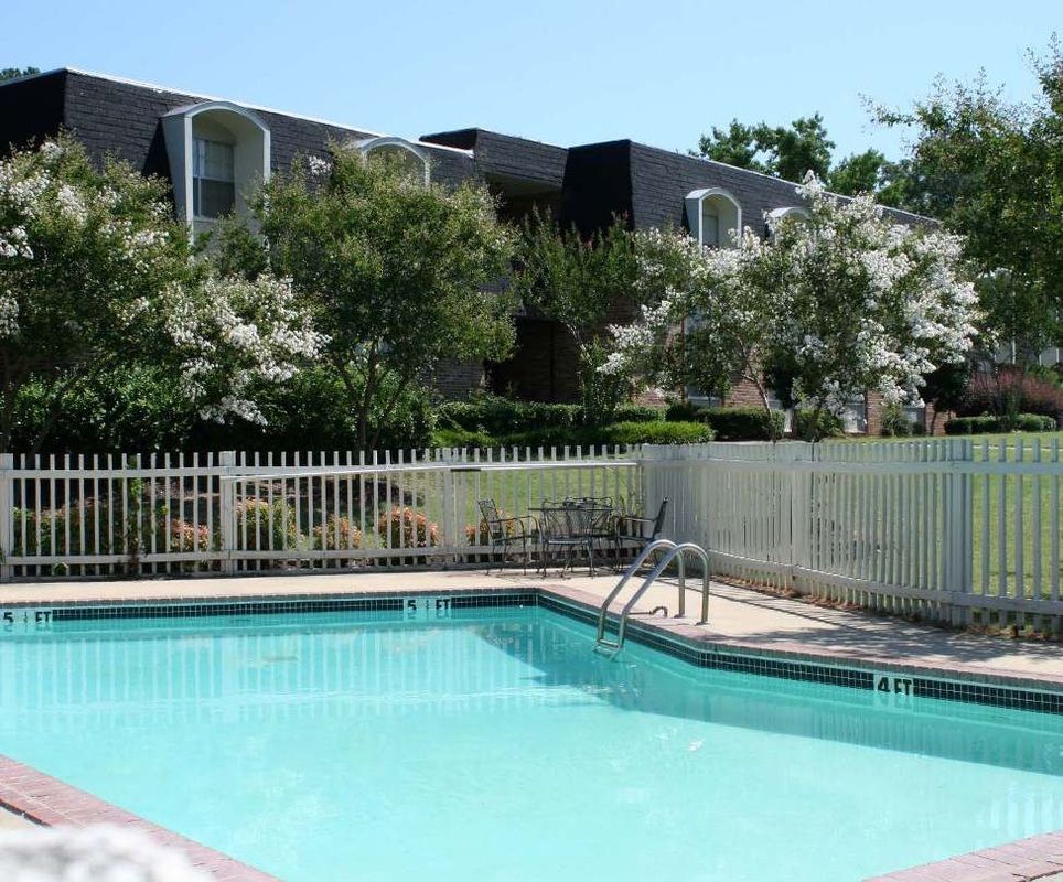 A large swimming pool with a white fence around it