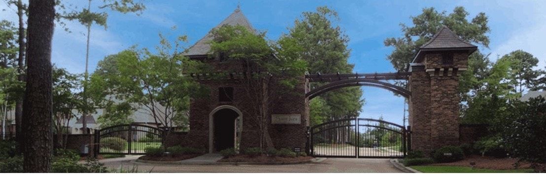 A stone building with a gate and trees in the background