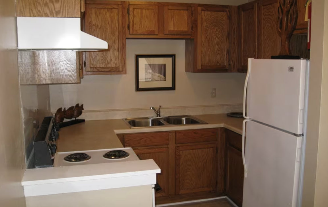 A kitchen with wooden cabinets and a white refrigerator