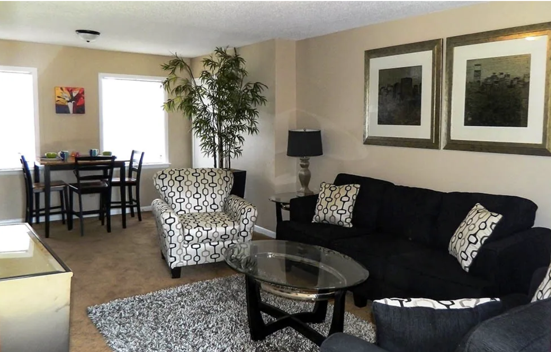 A living room with a black couch and chairs
