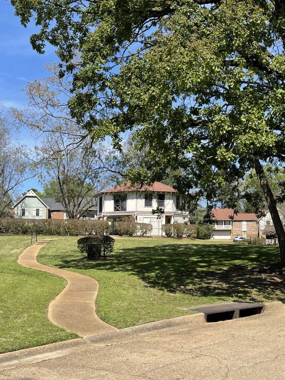 There is a path leading to a house in the background.