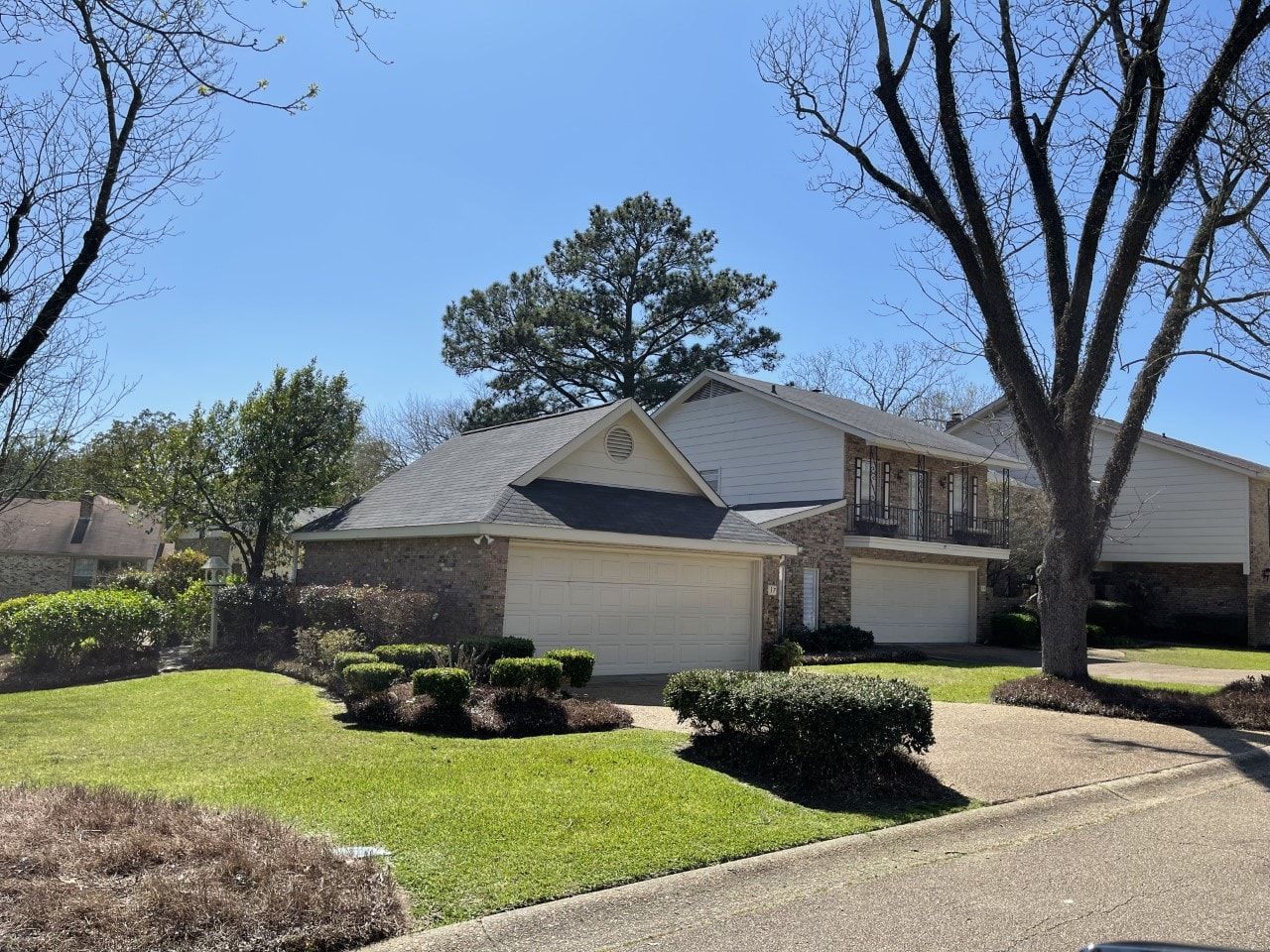 A house with two garages and a lush green lawn