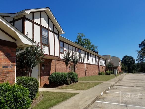 A brick building with a parking lot in front of it