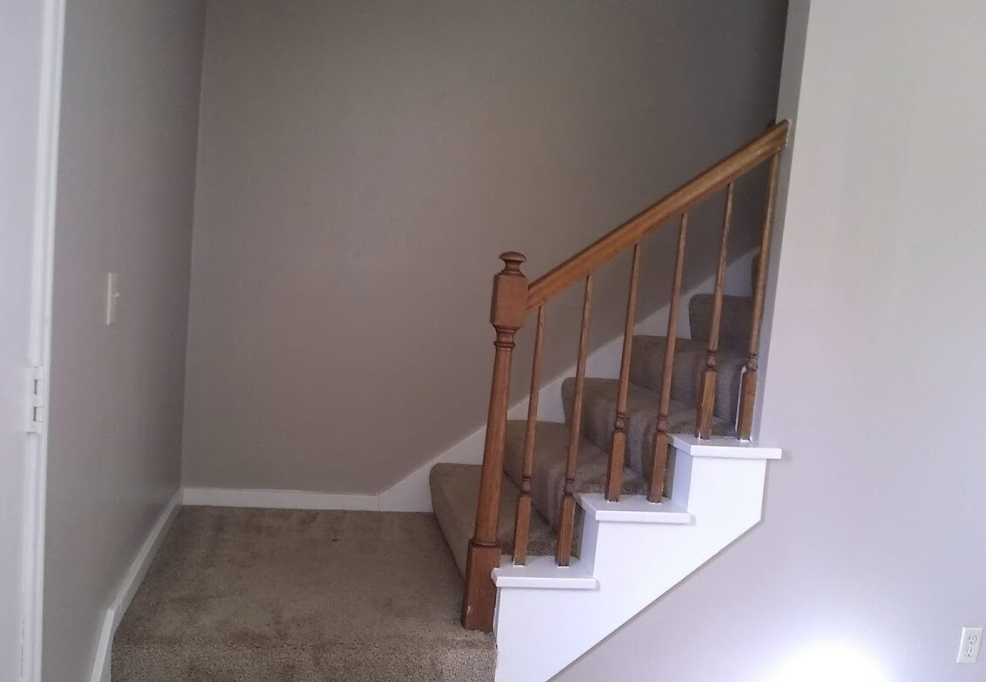 A staircase in a house with a wooden railing