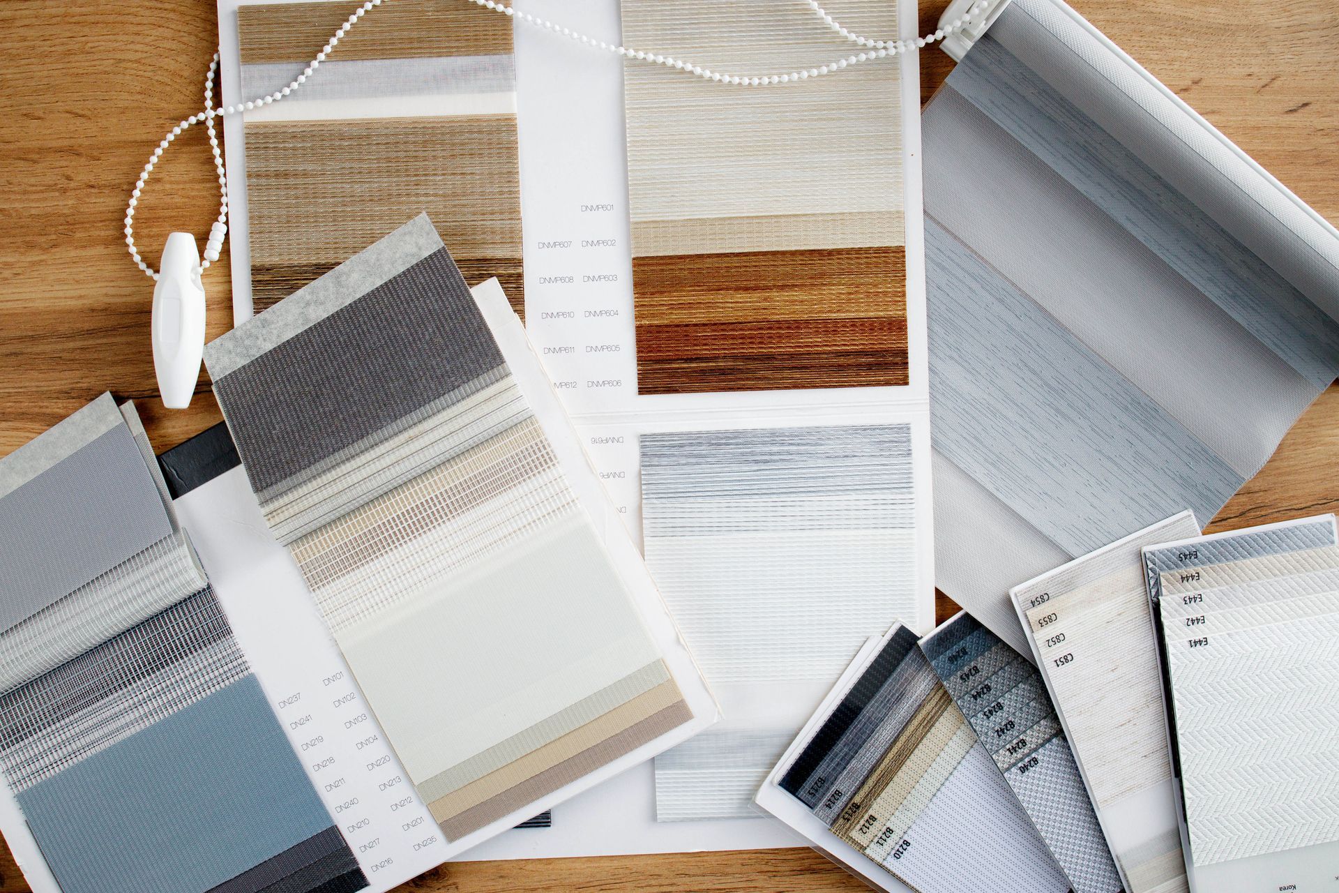 Open books and fabric swatches with color samples on a desk for interior design planning