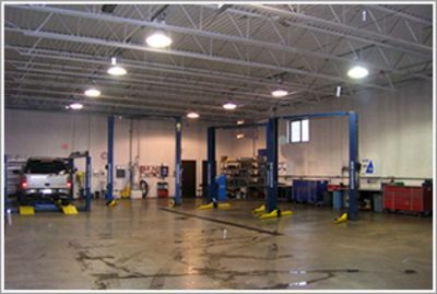 Auto repair garage with car lifts, tools, and a wet concrete floor | Automotive Physicians