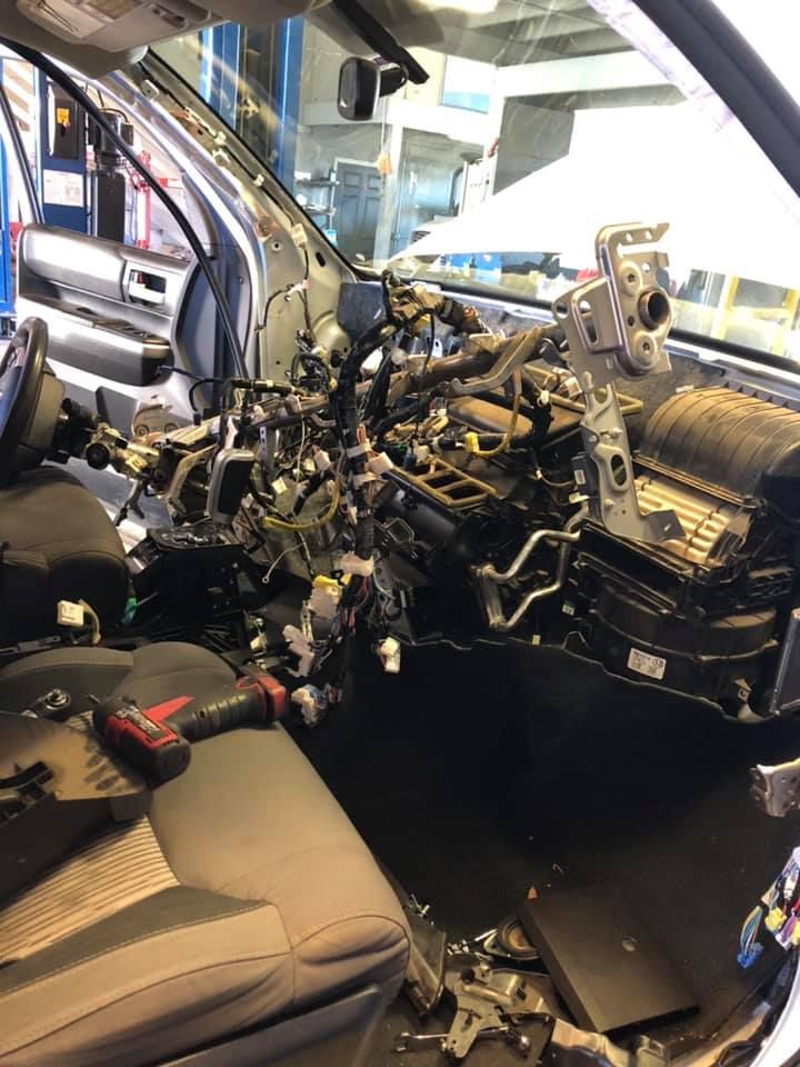 Car interior with dashboard removed, exposing engine components and wiring during repair | D&D Auto, LLC