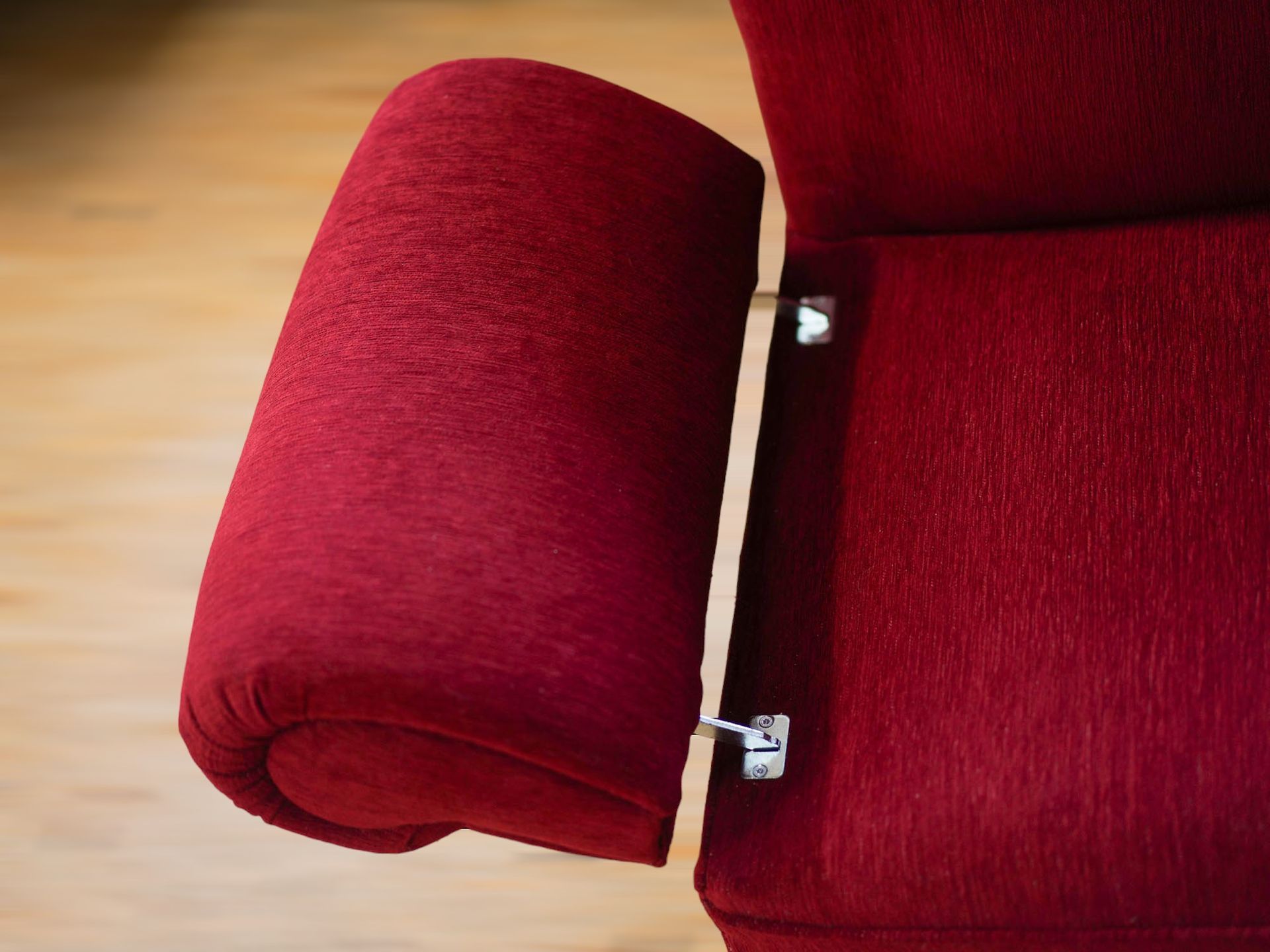 Eine Nahaufnahme der Armlehne eines rotes Sofa