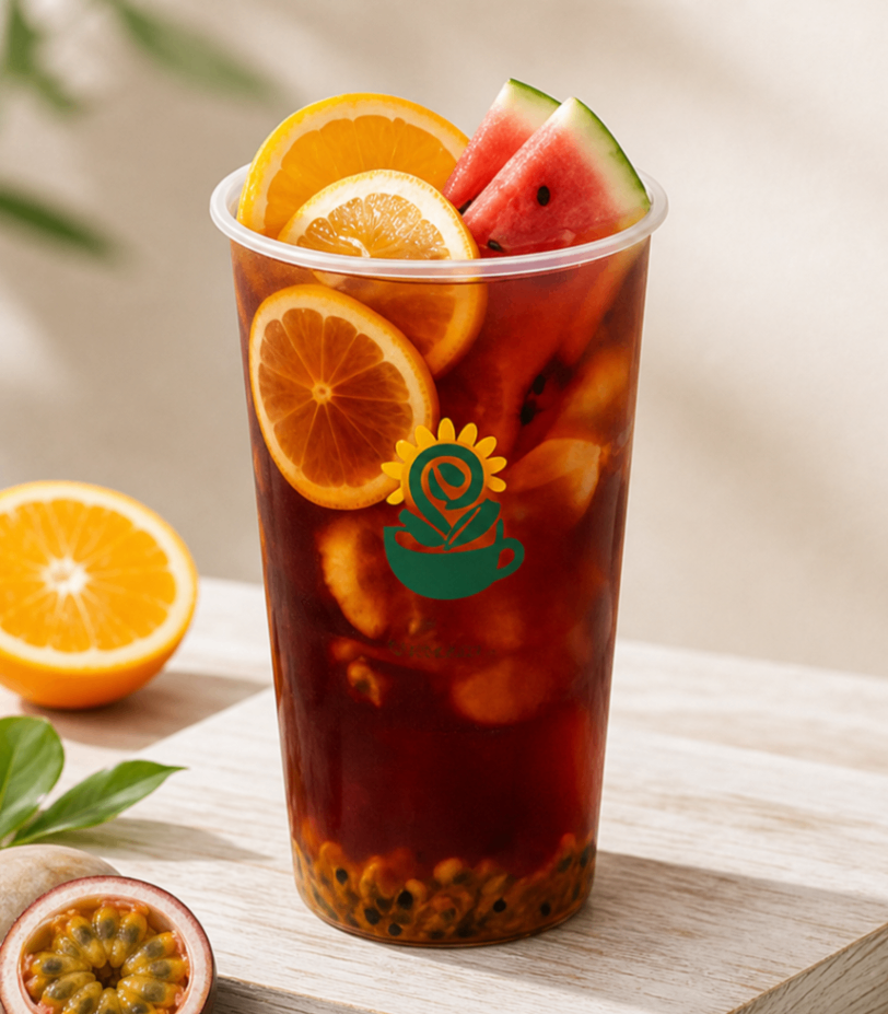 Iced fruit tea in a clear cup with orange, orange slice, watermelon, and passion fruit garnish