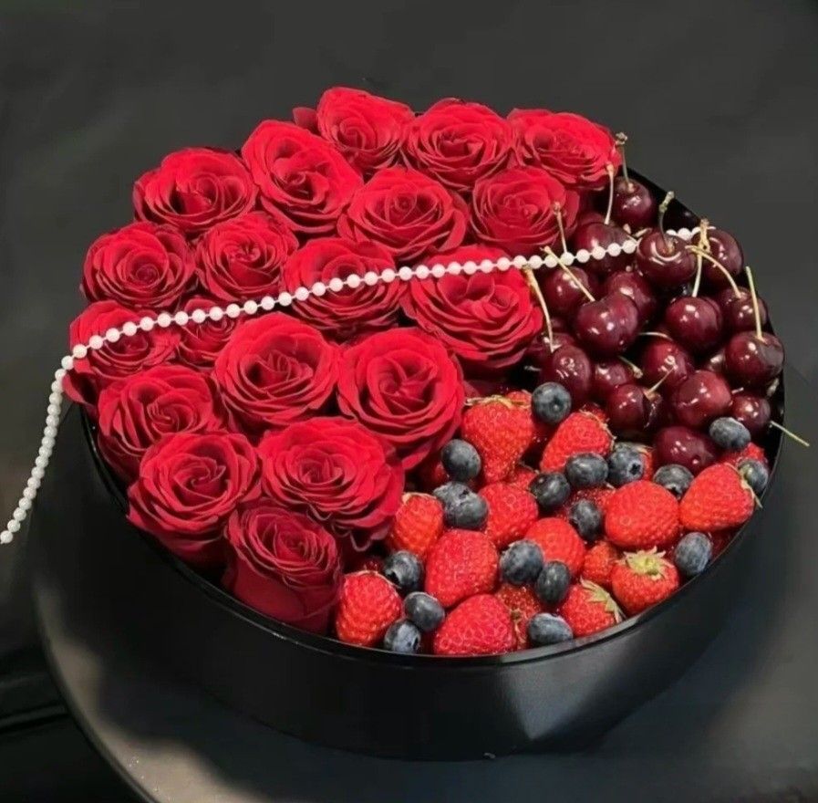 Heart-shaped gift box with red roses, pearls, red grapes, strawberries, and blueberries