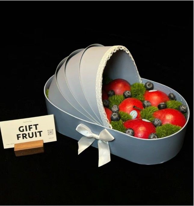 Heart-shaped gift fruit box with strawberries, grapes, and blueberries, beside a “GIFT FRUIT” sign