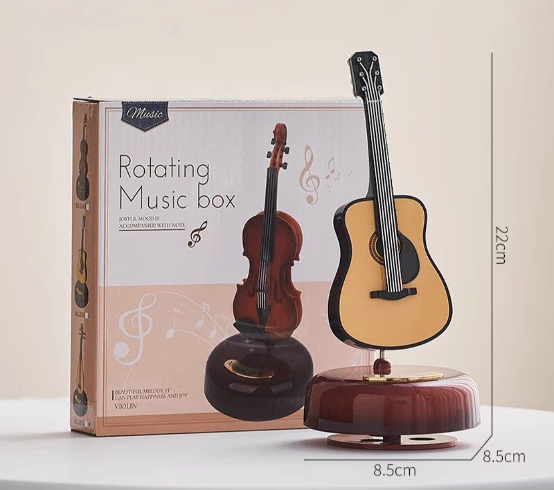 Boxed rotating music box with a guitar-shaped ornament on a wooden base