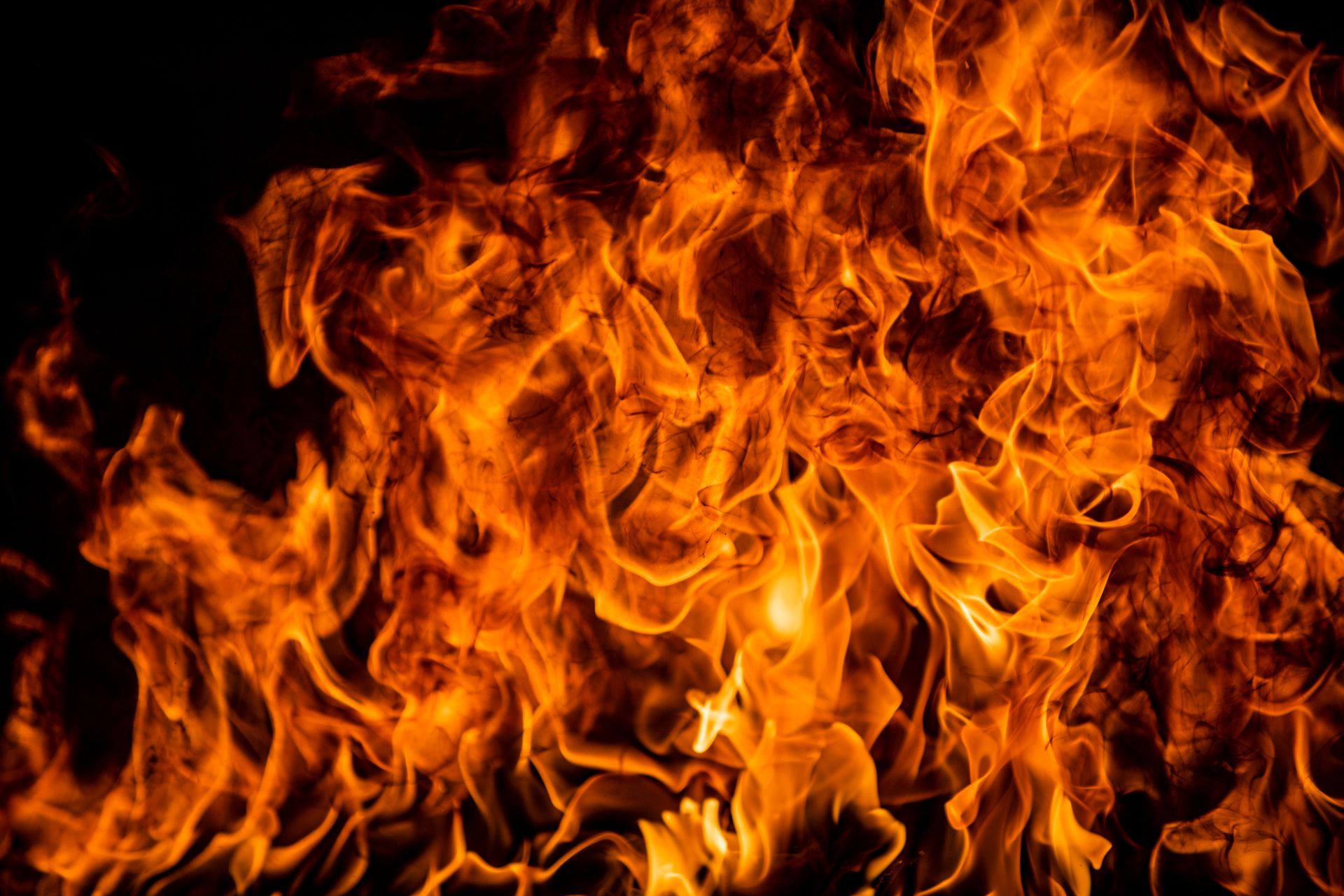 A bright orange flame flickering against a deep black background.