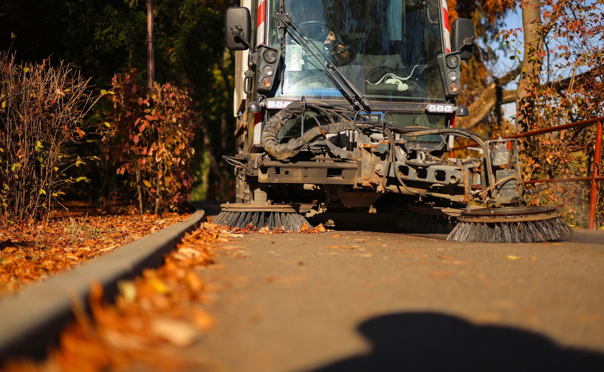 Professional lot cleaners maintaining clean pavement with industrial sweeping equipment.