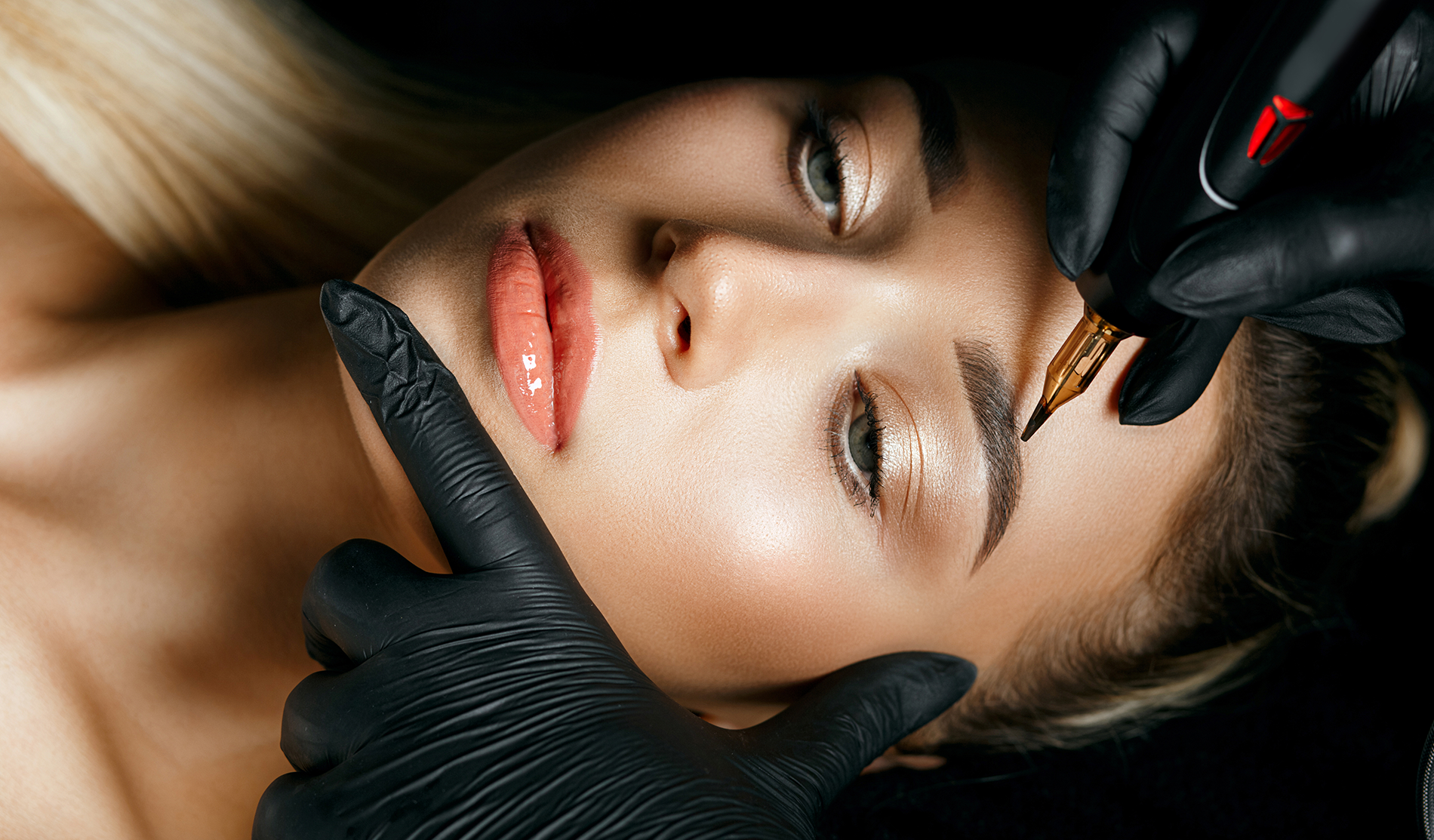 Eine Frau lässt sich ein Permanent-Make-up-Tattoo auf die Augenbrauen tätowieren.