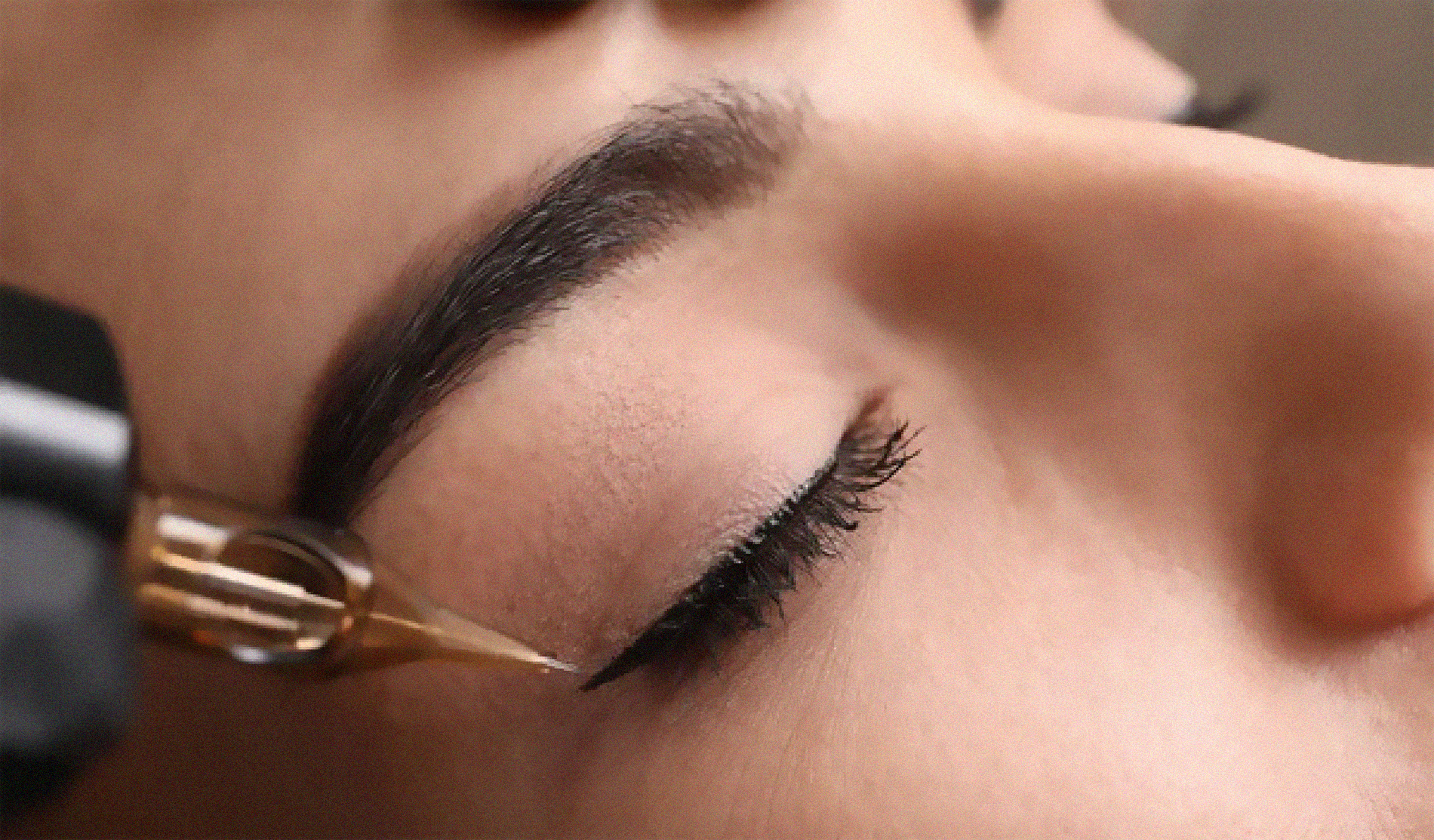 Eine Frau lässt sich ein Eyeliner-Tattoo aufs Auge tätowieren.