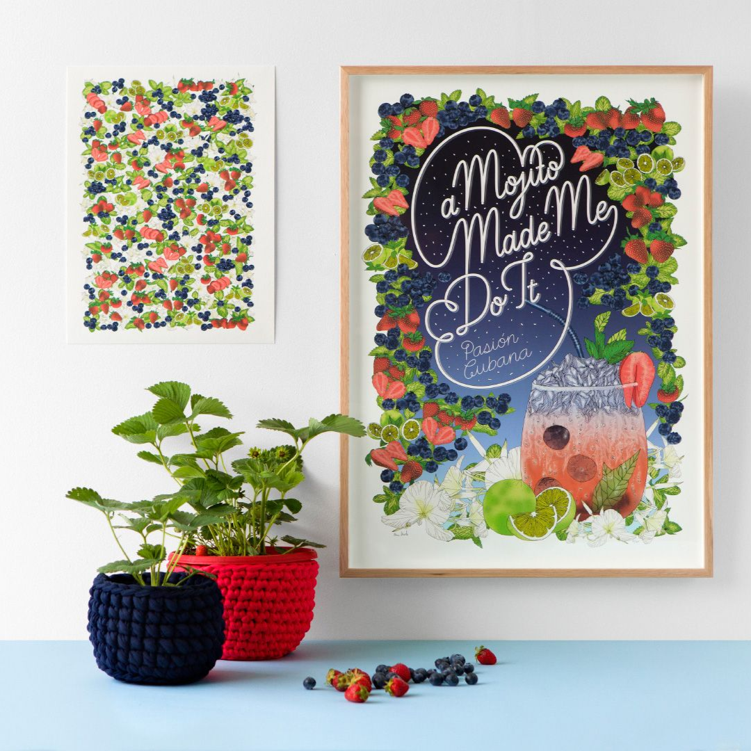 Framed floral poster with “Mama Made Me Do It,” beside two potted plants on a white surface