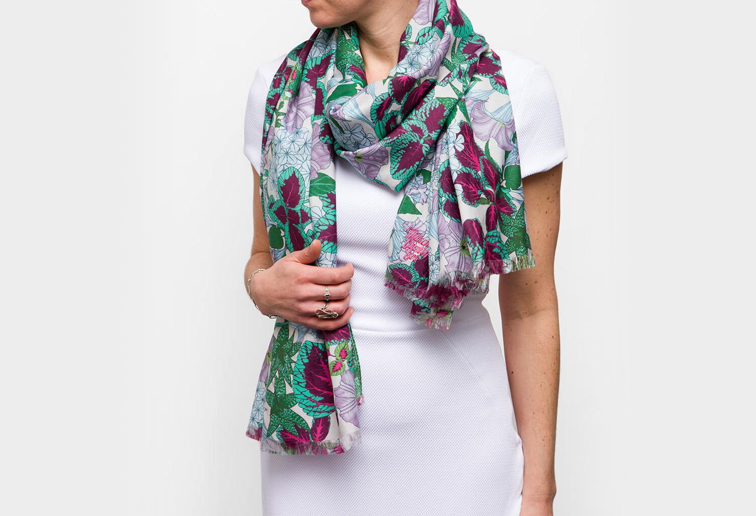 Maria Montes wearing a white dress and colorful patterned scarf against a plain background