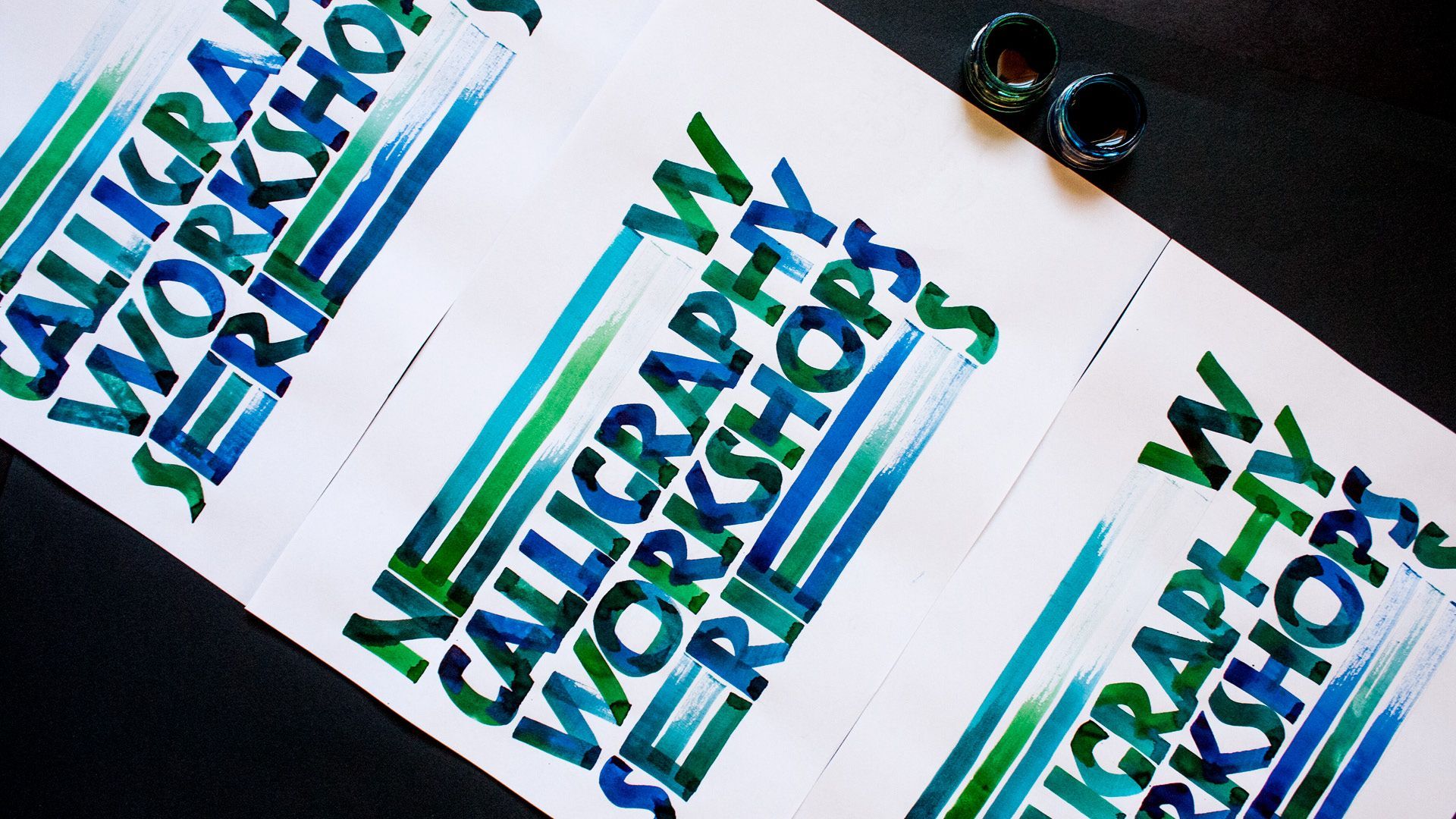 Blurred teal-and-blue typography on white cards, overlapping at angles on a dark background.
