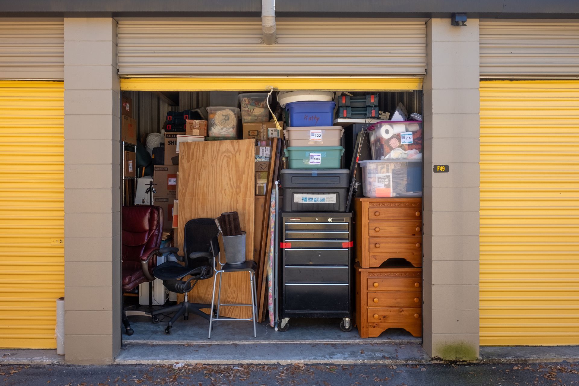 Open storage unit filled with boxes, furniture, and household items.