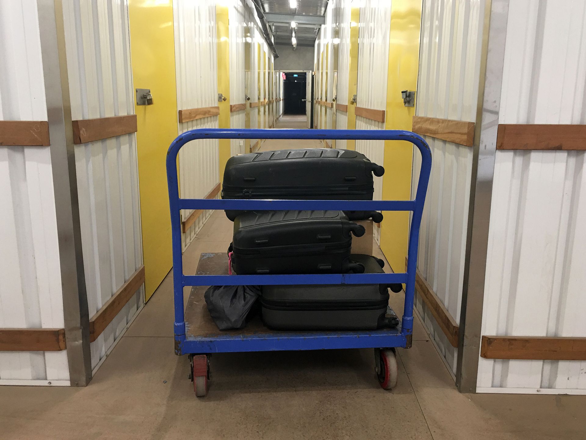 Full trolley luggage in unrecognizable self-storage place.