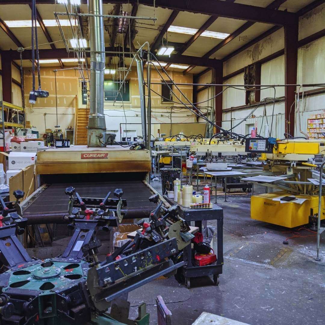 Industrial workshop with large yellow machinery, metal equipment, and tools inside a factory warehouse