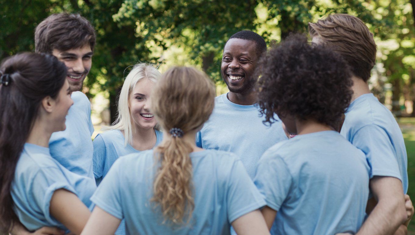 Group of diverse people wearing custom tees and having fun during a community event.