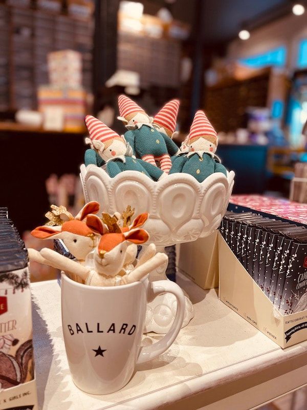 Dessert display with unicorn-themed sweets in white cups on a tray at a shop counter