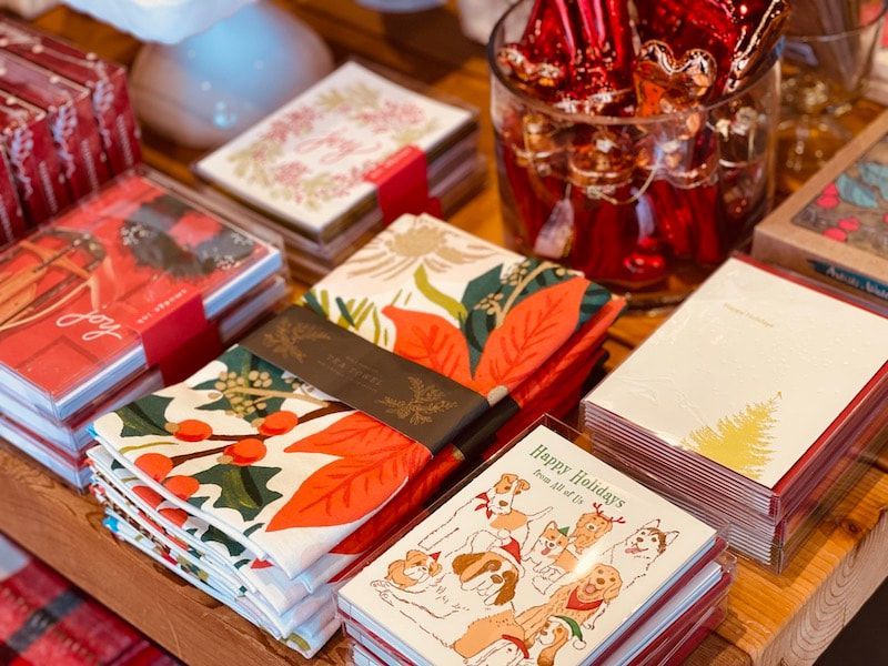 Assorted floral notebooks and stationery in warm red and cream tones on a table