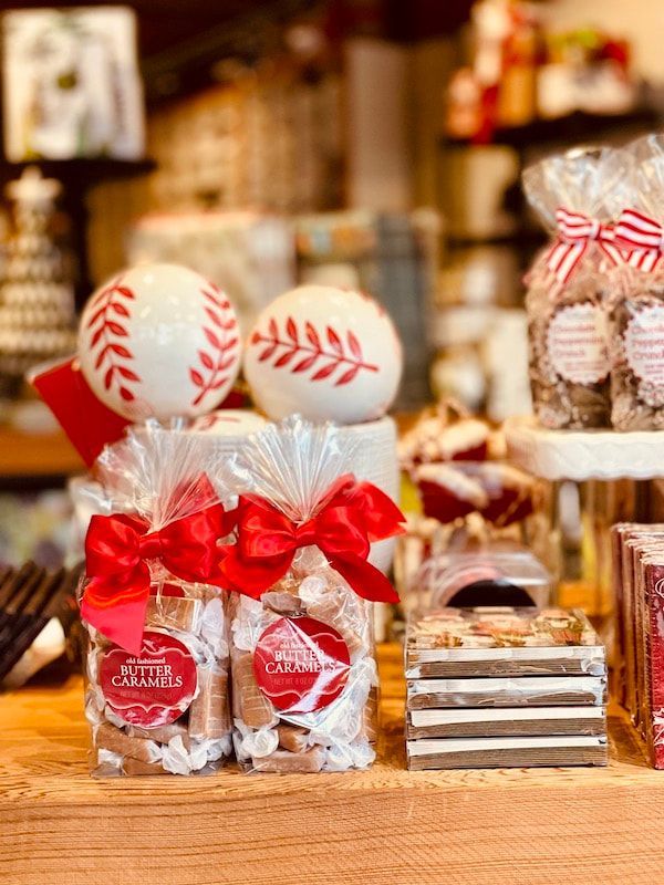 Candy bags with red ribbons and baseball decorations on a shop counter