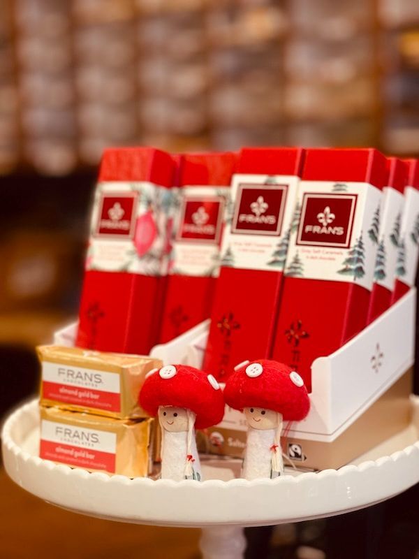 Red Fran’s gift boxes with mushroom ornaments on a white display tray