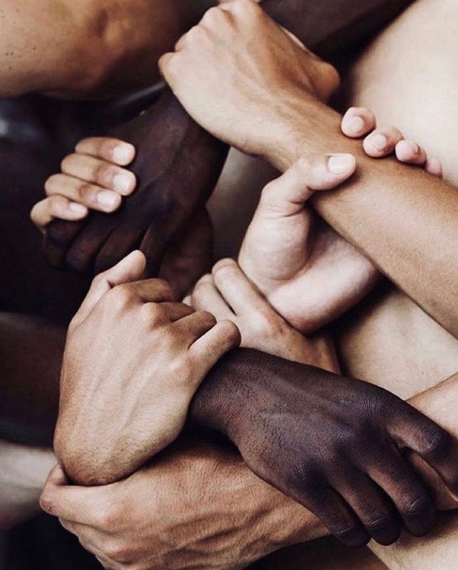 Interlocked hands of diverse skin tones symbolizing unity and teamwork